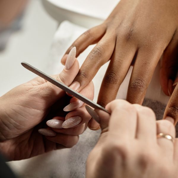 Profissional manicure prepara as unhas de sua cliente para criar as polka dot nails