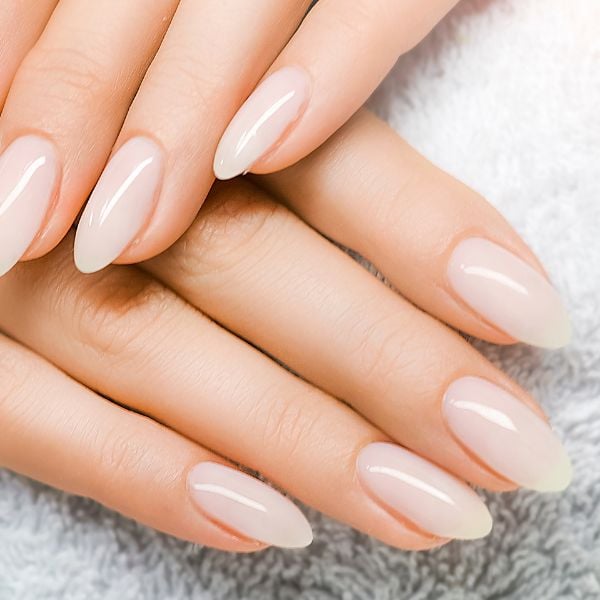 Foto das mãos de uma mulher com manchas brancas nas unhas enquanto ela cuida de suas unhas.