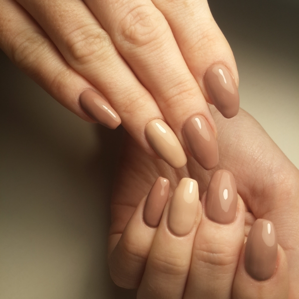 Foto de mãos com esmalte marrom ideal para o outono.