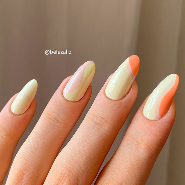 Unhas descombinadas com tons de amarelo, laranja e cinza