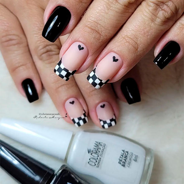 Detalhe das mãos de uma manicure pintando as unhas com um desenho de  esmalte preto