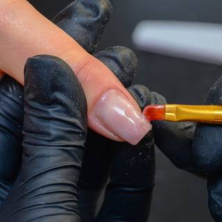 Nail designer aplicando gel sobre a unha