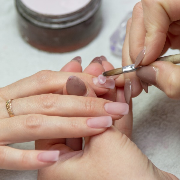 Nail designer aplicando gel na unha