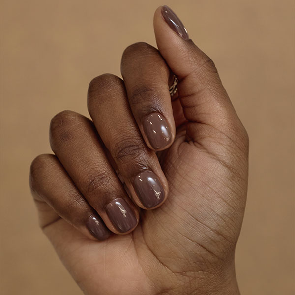 Esmalte nude marrom escuro valoriza a beleza da mão negra, proporcionando um visual sofisticado e moderno