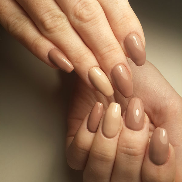Diferentes tons de esmalte nude criam um degradê sofisticado em unhas decoradas, ideal para ocasiões especiais