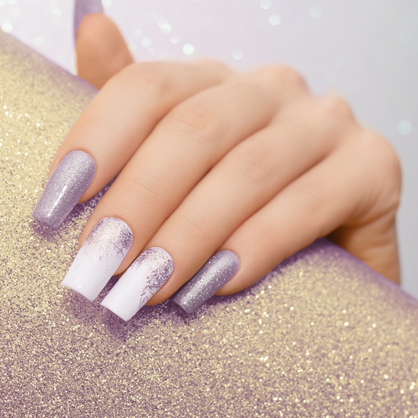 Mãos com unha branca com glitter.