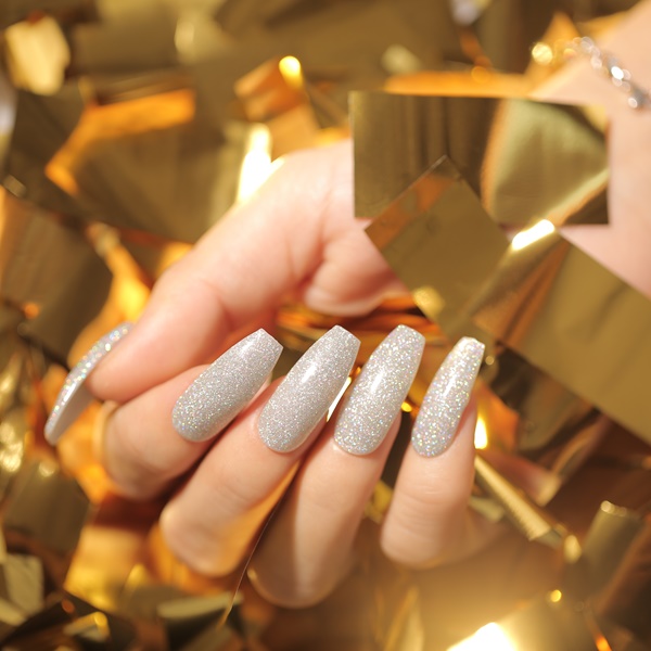 Unhas brancas com glitter prateado para o ano novo.