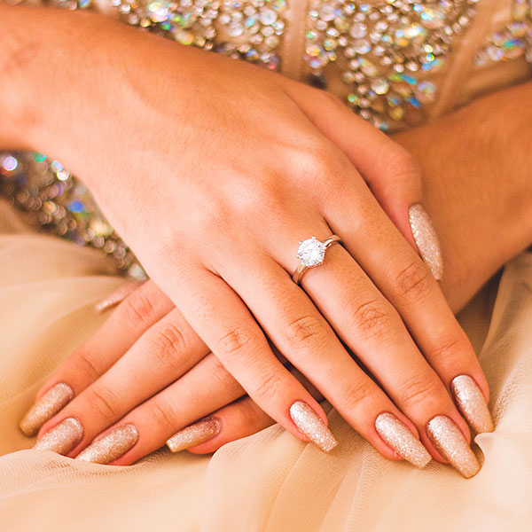 Pessoa com unhas decoradas nude com dourados