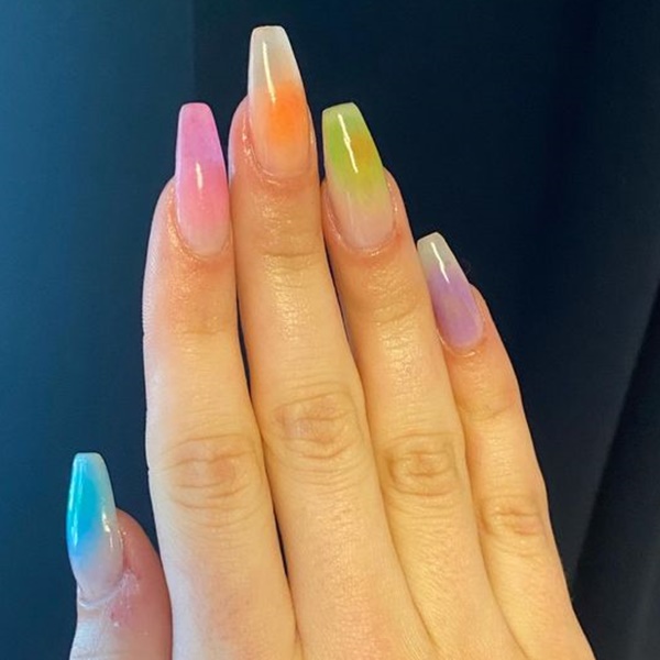 Modelo com unhas degradê em tons coloridos pasteis