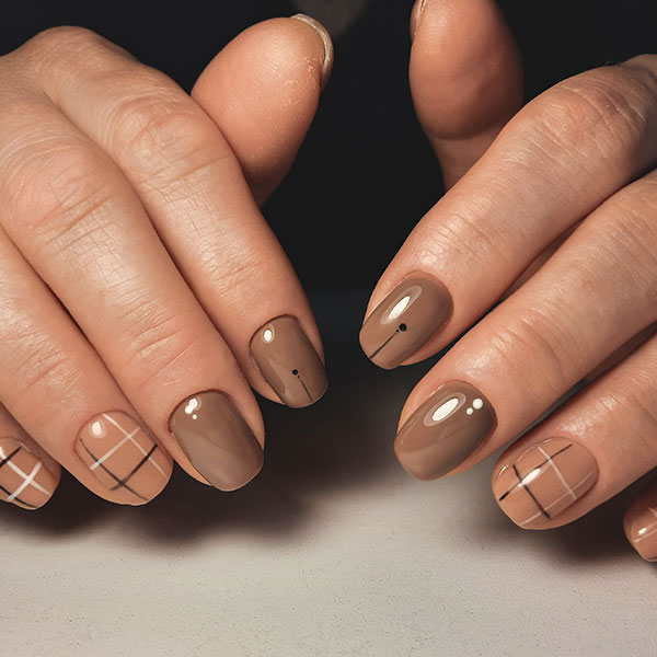 Modelo com unhas decoradas em xadrez