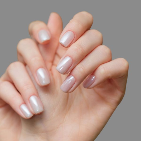 Mão com as unhas em tom perolado.