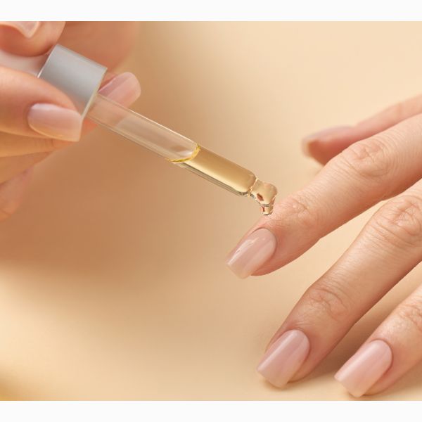 Mulher hidratando suas cutículas com óleo.
