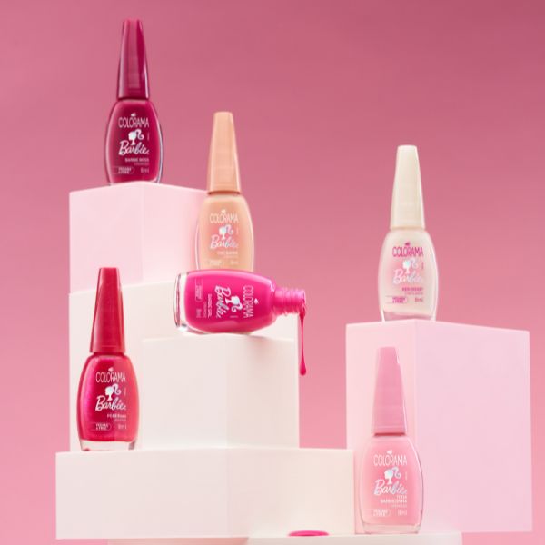 Foto da Coleção Barbie™ + Colorama com os esmaltes posicionados em uma estrutura branca em fundo rosa.