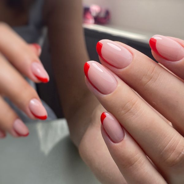 Mão com francesinha vermelha nas unhas. 