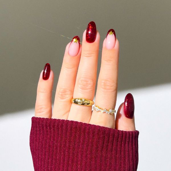 Mão com nail art vermelho cereja nas unhas.
