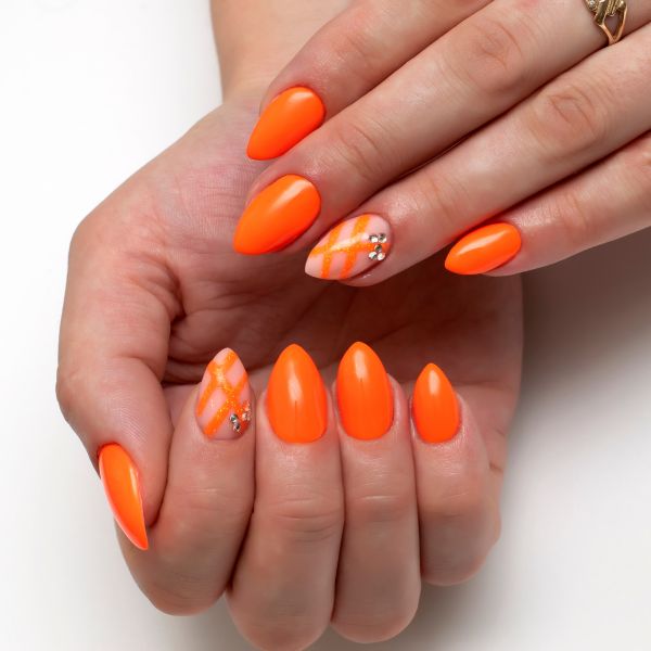 Unhas laranja neon com nail art.