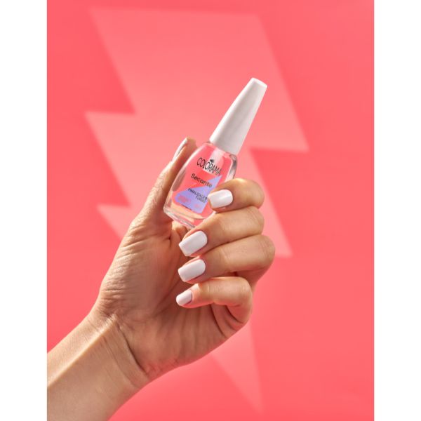 Mão segurando o esmalte Secante Turbo de Colorama em fundo rosa com um raio no meio.