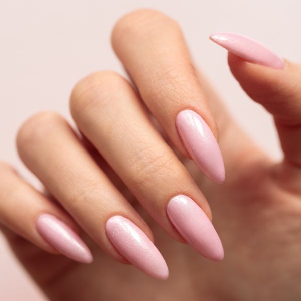 Mão com unhas rosa claro grandes.