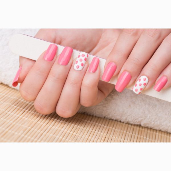 Unhas rosa claro e dedo anelar com unha branca e poá rosa.