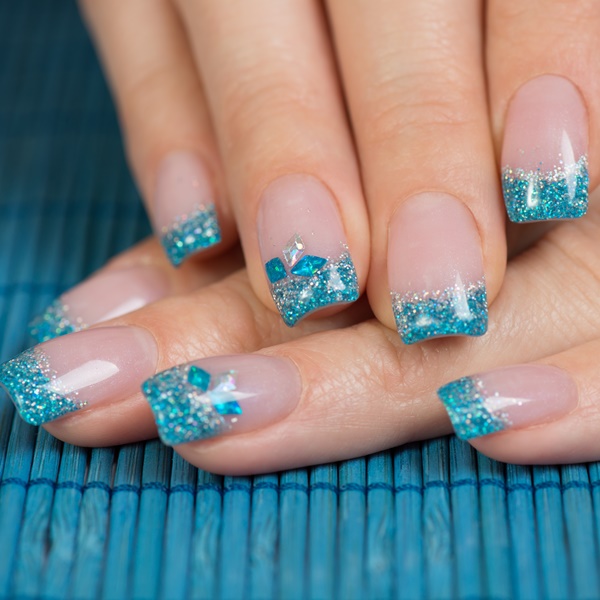 Mãos com francesinha com glitter nas unhas.