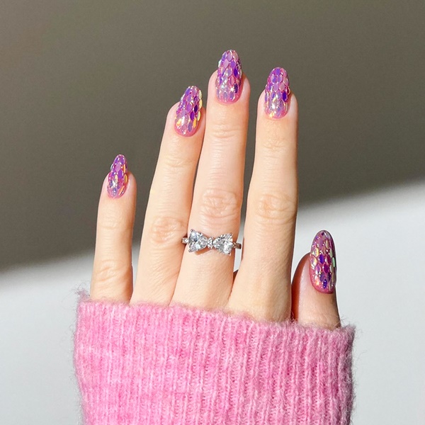 Mão com unhas com glitter metalizadas.