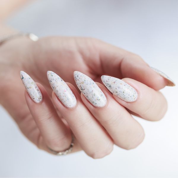 Unhas brancas com glitter grande prata.