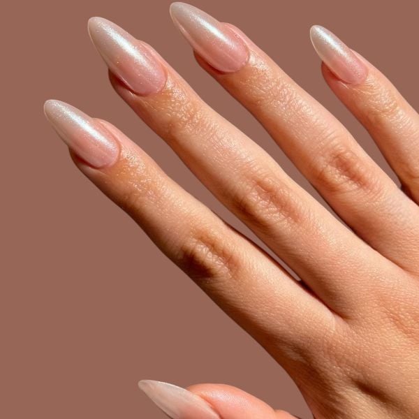 Mão com unhas simples em tom perolado.