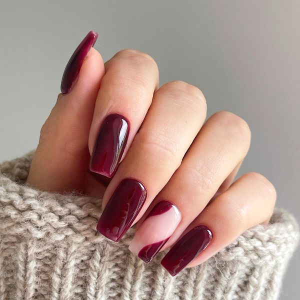 Mão com unhas simples em tom de roxo e dedo anelar com nail art.