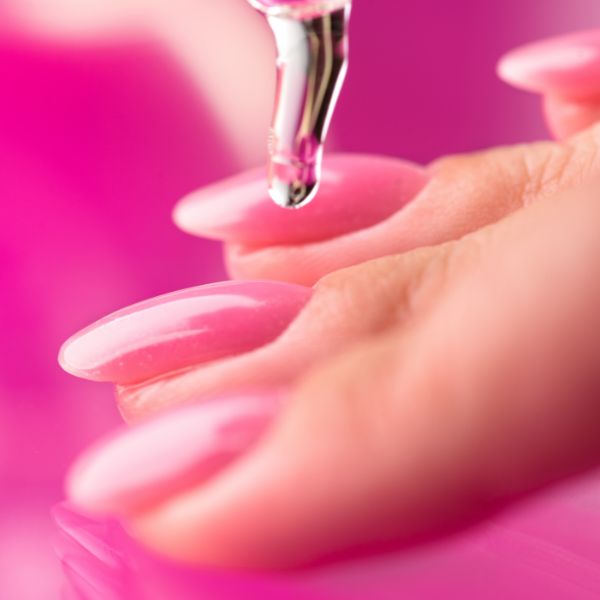 Unhas cor de rosa finalizadas com óleo secante.