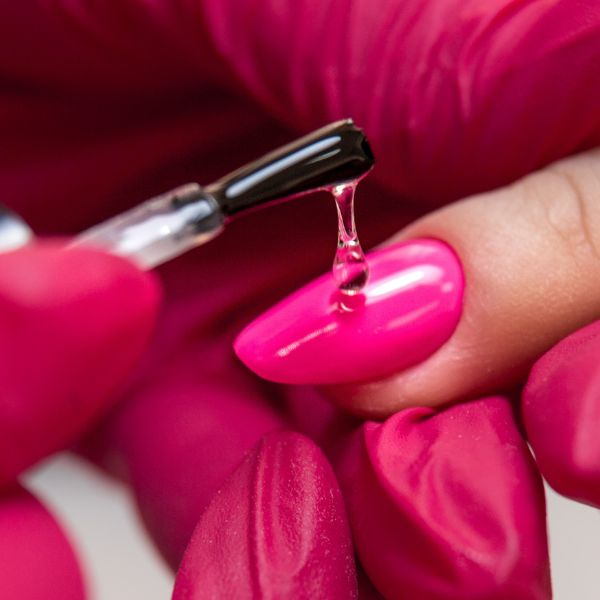 Unha rosa pink, sendo finalizada com esmalte  secante turbo.