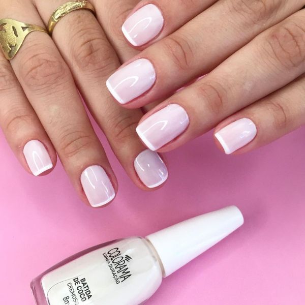 Unhas feitas com uma base rosa clara e uma francesinha muito fina, a micro french, como detalhe em todas as unhas.