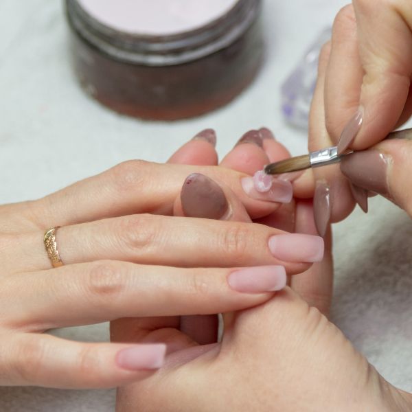 Profissional manicure cuida das unhas de sua cliente para evitar fungos nas unhas ou onicomicose.