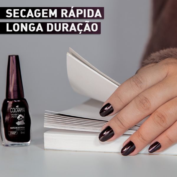 Foto de uma mão abrindo um livro e separando suas páginas, com as unhas pintadas no tom produnso brilhante “Noite de Estreia” ao lado de um vidro do esmalte.