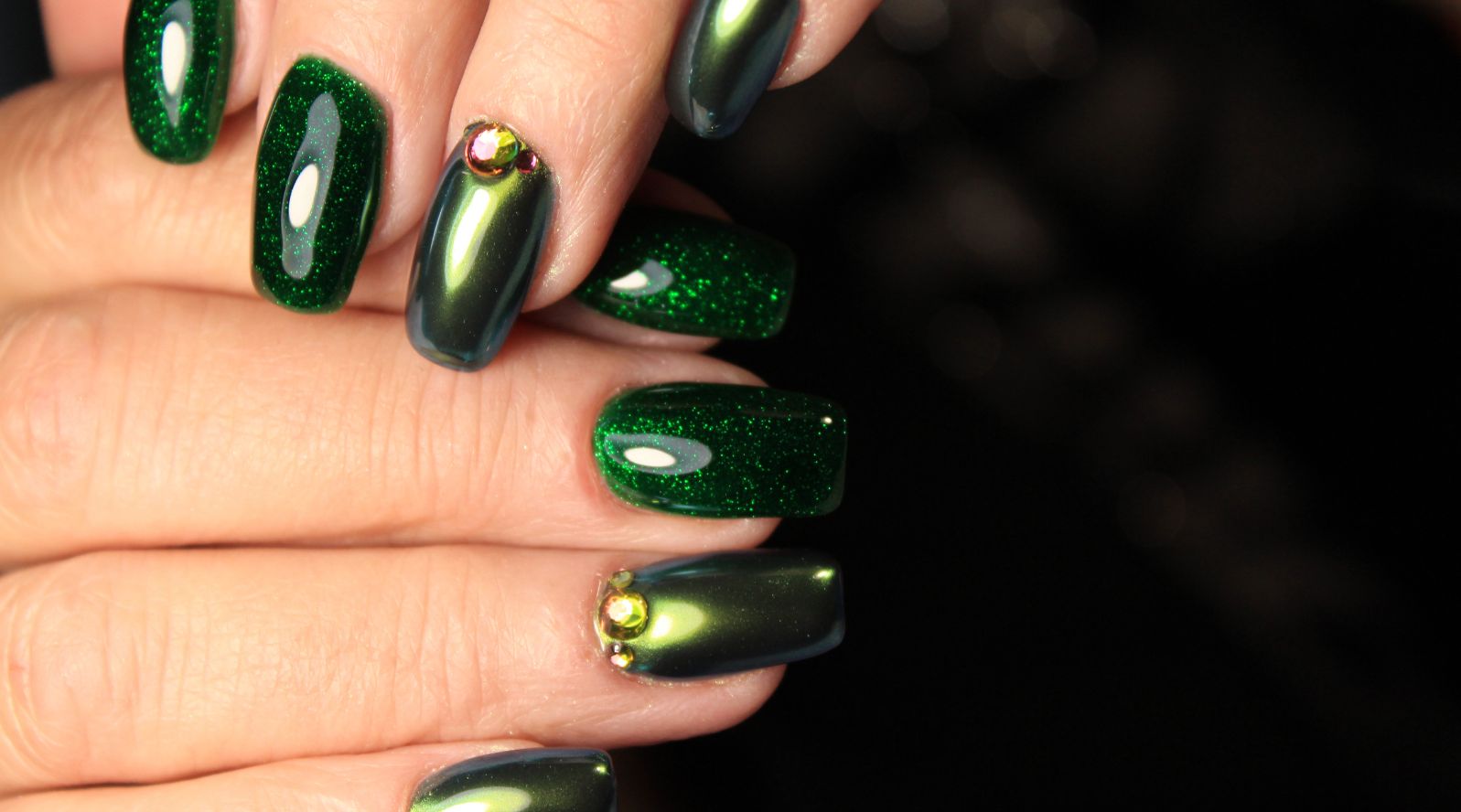 Unhas pintadas com esmalte verde e efeito metalico.