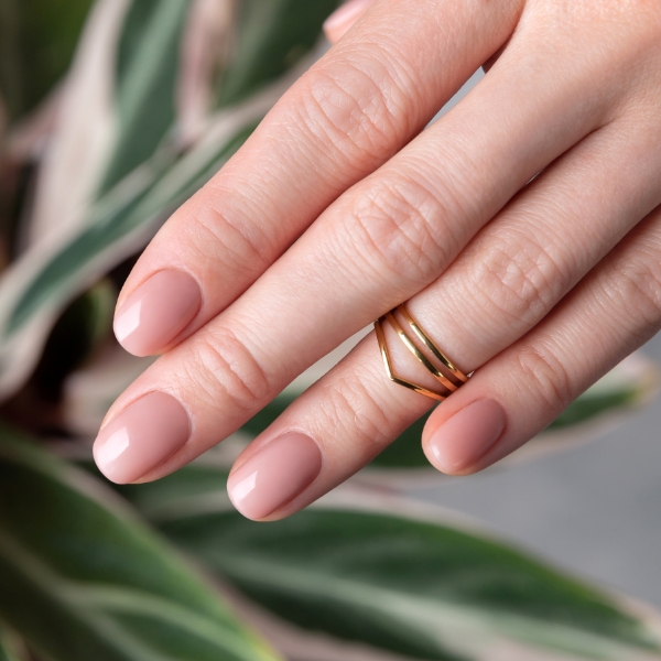 Foto de unhas nude peroladas com top coat para realçar o brilho da esmaltação simples.