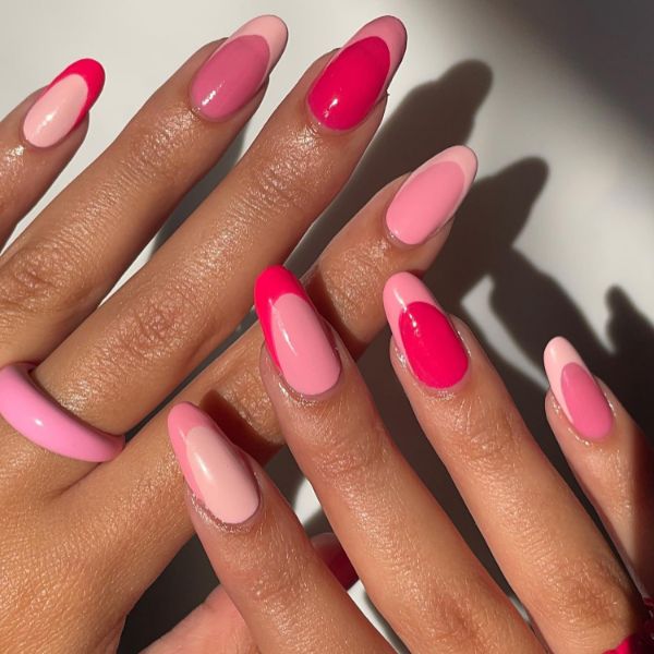 Unha rosa em formato oval com design de duas cores, combinando diferentes tons de rosa vibrante.