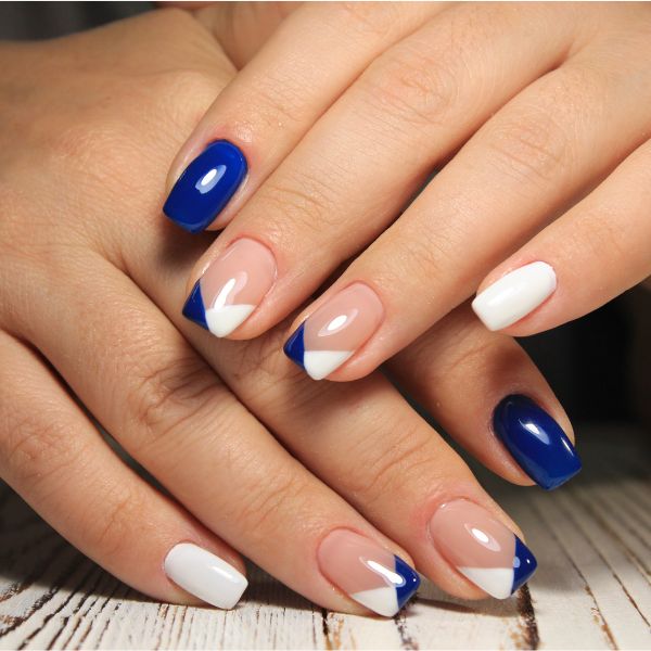 Foto de unhas feitas em esmalte verde escuro, com a filha única estampada com a bandeira do Brasil.