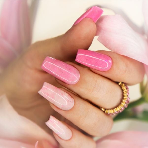Foto de mão com as unhas rosa degradê