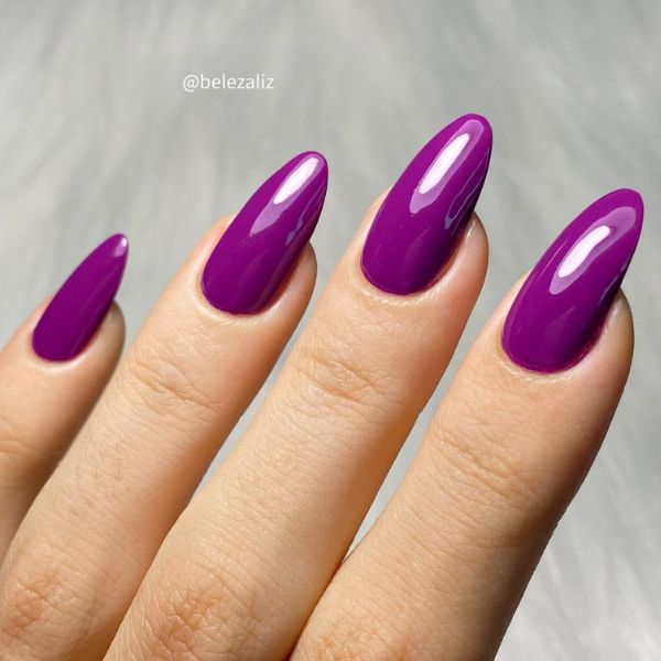 Foto de unhas pintadas com um esmalte roxo.