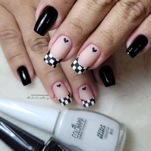 Foto de esmaltação onde o dedo mindinho e indicador estão pintados de preto e o dedo anelar e do meio têm uma base nude com uma francesinha xadrez preta e branca, pintadas com esmaltes Colorama indicados logo a baixo.