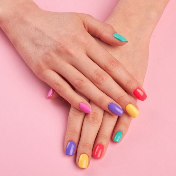 Foto de unhas com cores diferentes e intensas com top coat para o Carnaval.