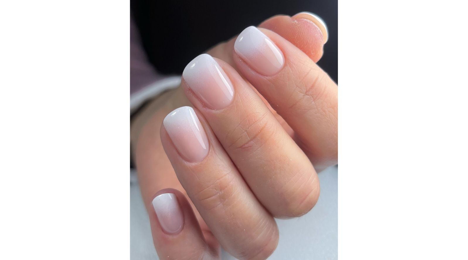 Unhas com pintura degrade, do nude ao branco.