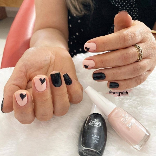 Detalhe das mãos de uma manicure pintando as unhas com um desenho de  esmalte preto