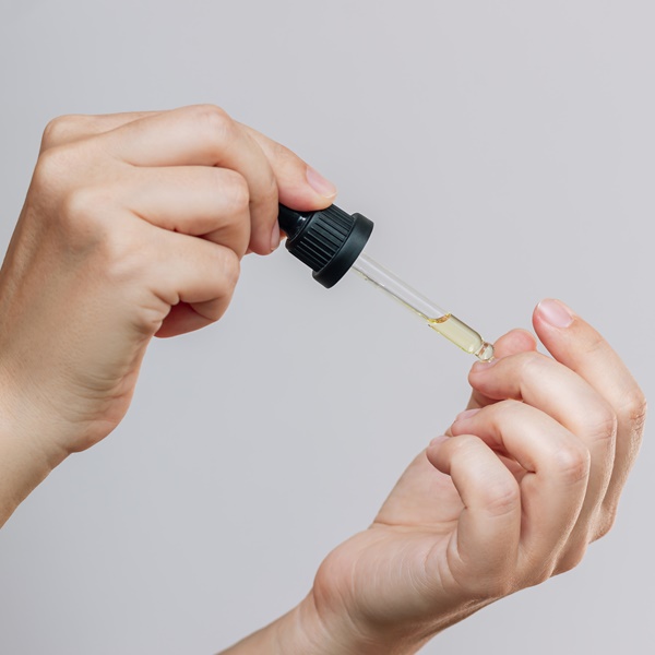 Mulher passando óleo de coco de babaçu nas cutículas.